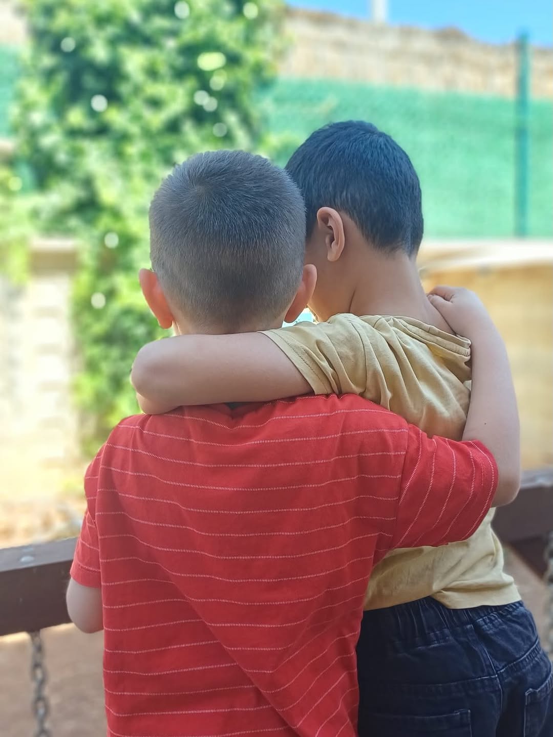 Bahçede kucaklaşan iki çocuk